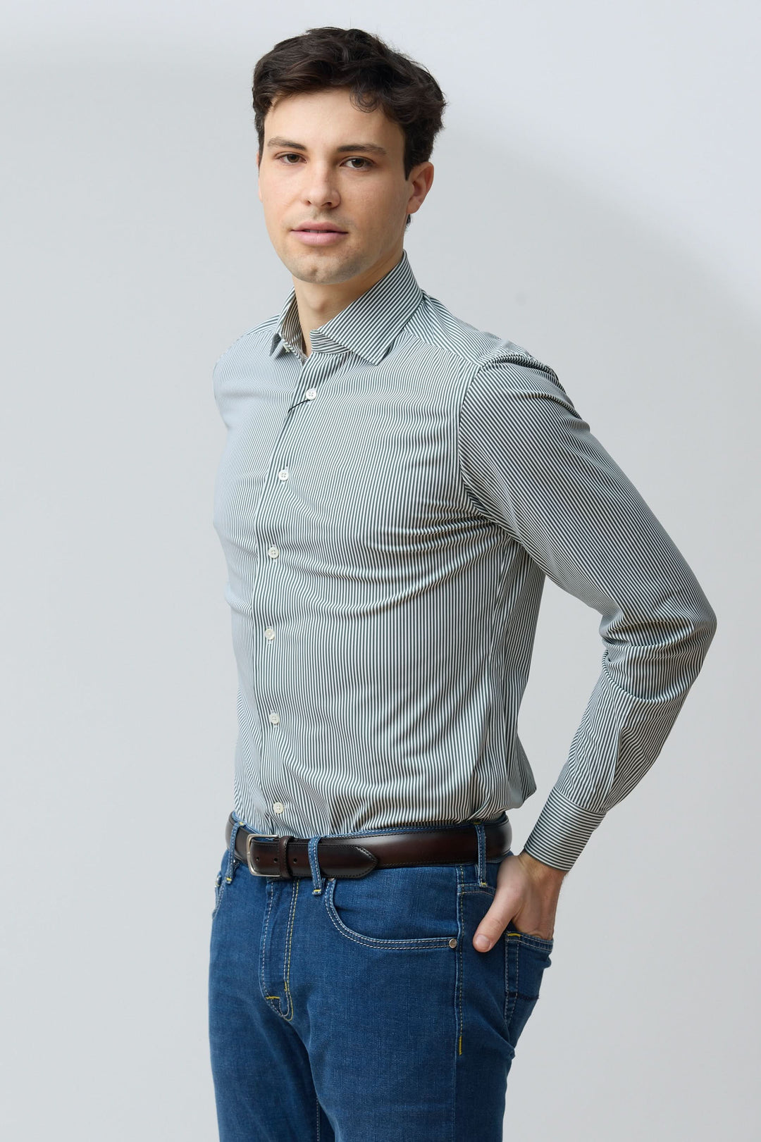 Homme portant une chemise à rayures vertes fines, coupe ajustée, moderne et confortable, pour un look professionnel ou décontracté.
