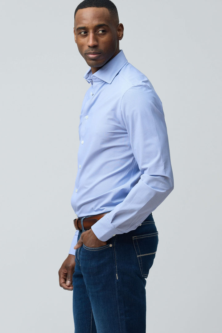 Homme portant une chemise structurée à micro-motif bleue, coupe ajustée, élégante pour bureau et sorties habillées.