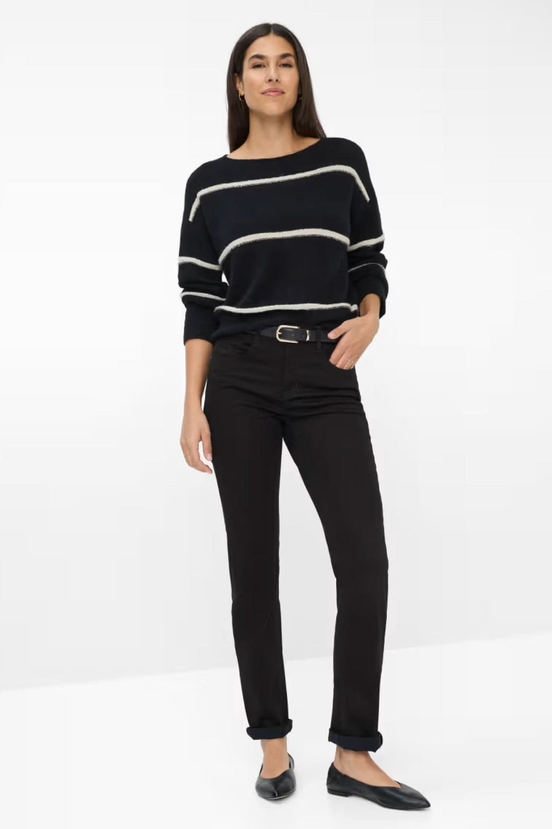 Femme portant un Chino de style Mary noir, coupe ajustée, avec un pull rayé élégant.