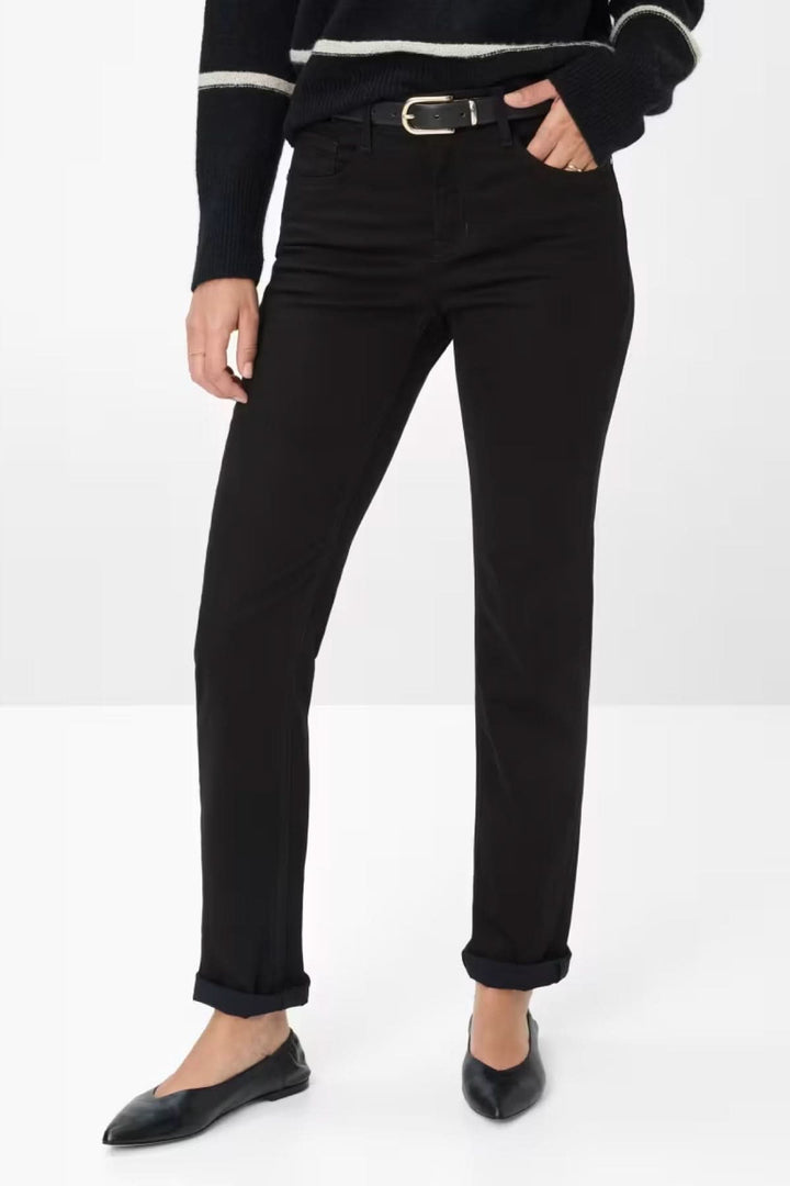 Femme portant un Chino de style Mary noir ajusté avec ceinture, associé à un pull rayé pour un look casual chic élégant.