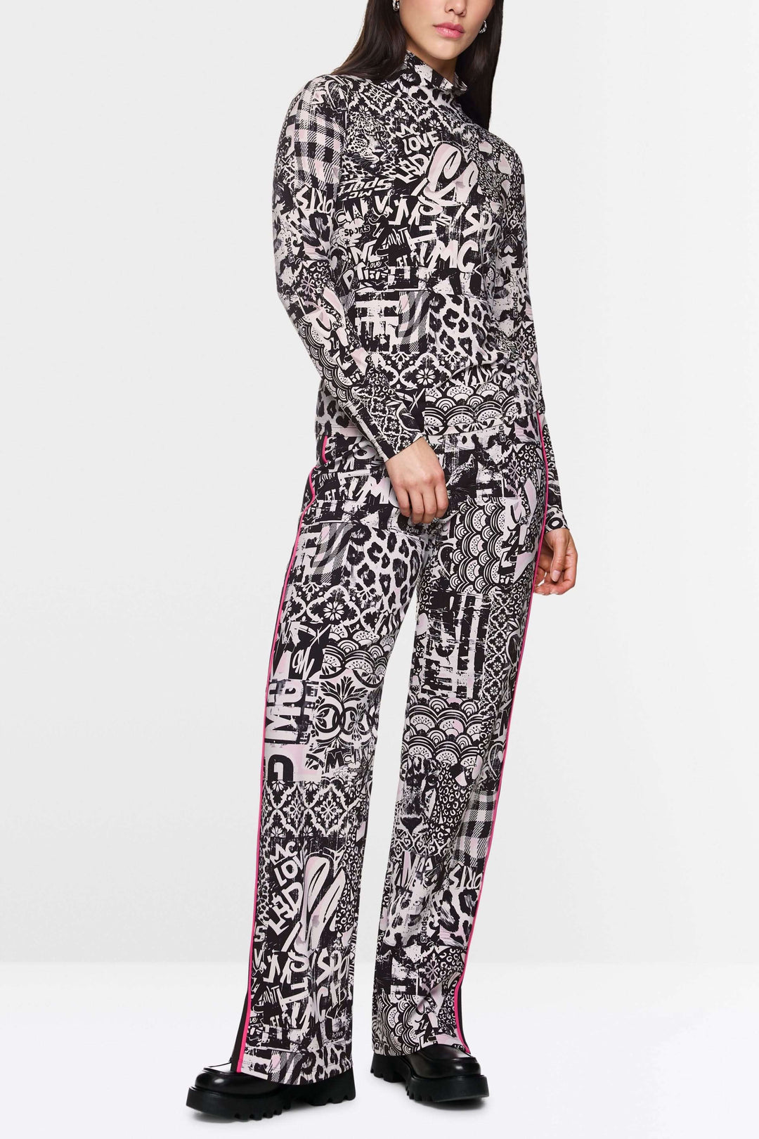 Col roulé imprimé avec motifs graphiques audacieux, associé à un pantalon assorti, pour un look moderne et tendance.