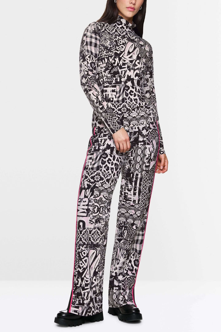 Col roulé imprimé avec motifs graphiques audacieux, associé à un pantalon assorti, pour un look moderne et tendance.