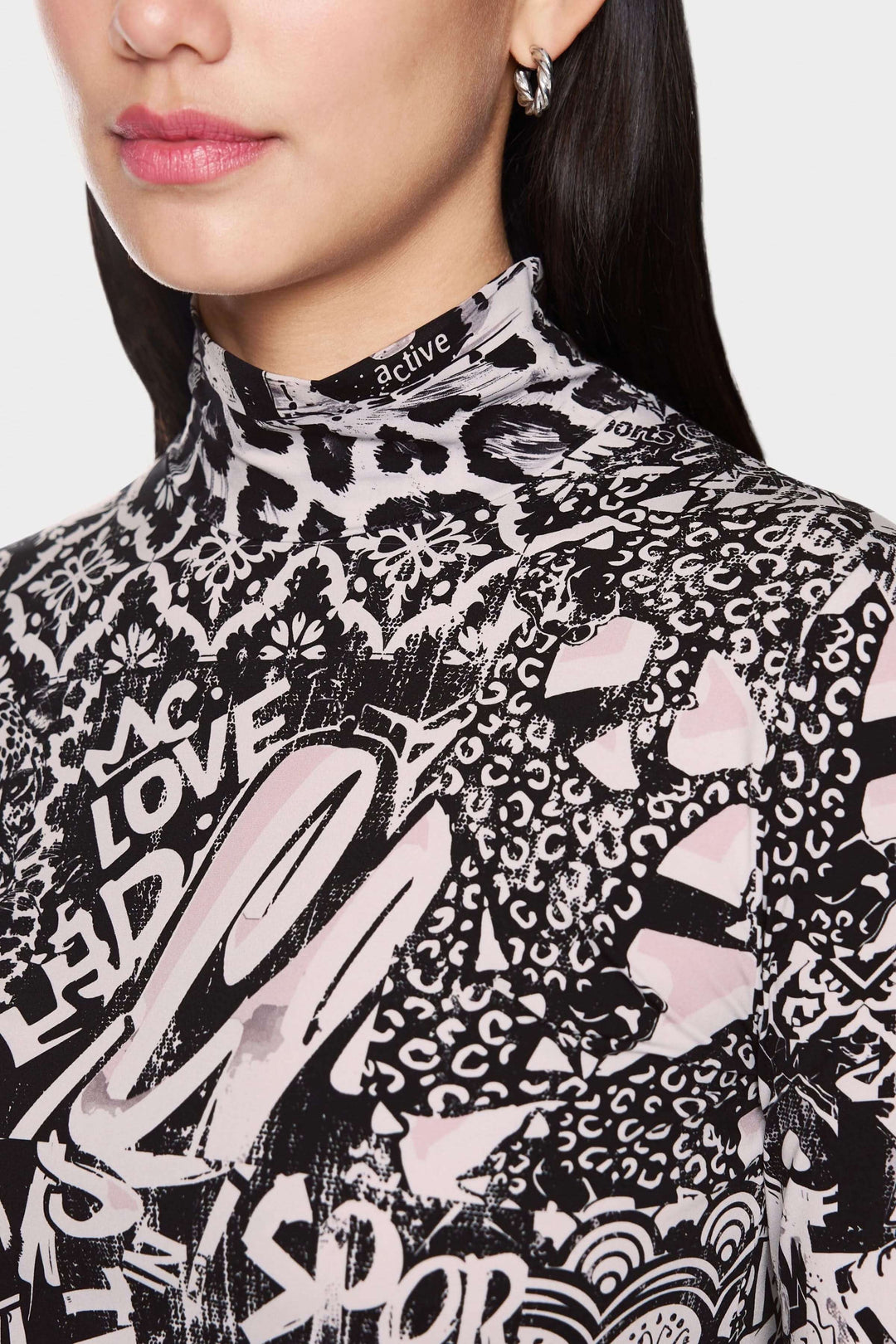 Col roulé imprimé avec motifs graphiques modernes, coupe ajustée et tissu extensible, style tendance.