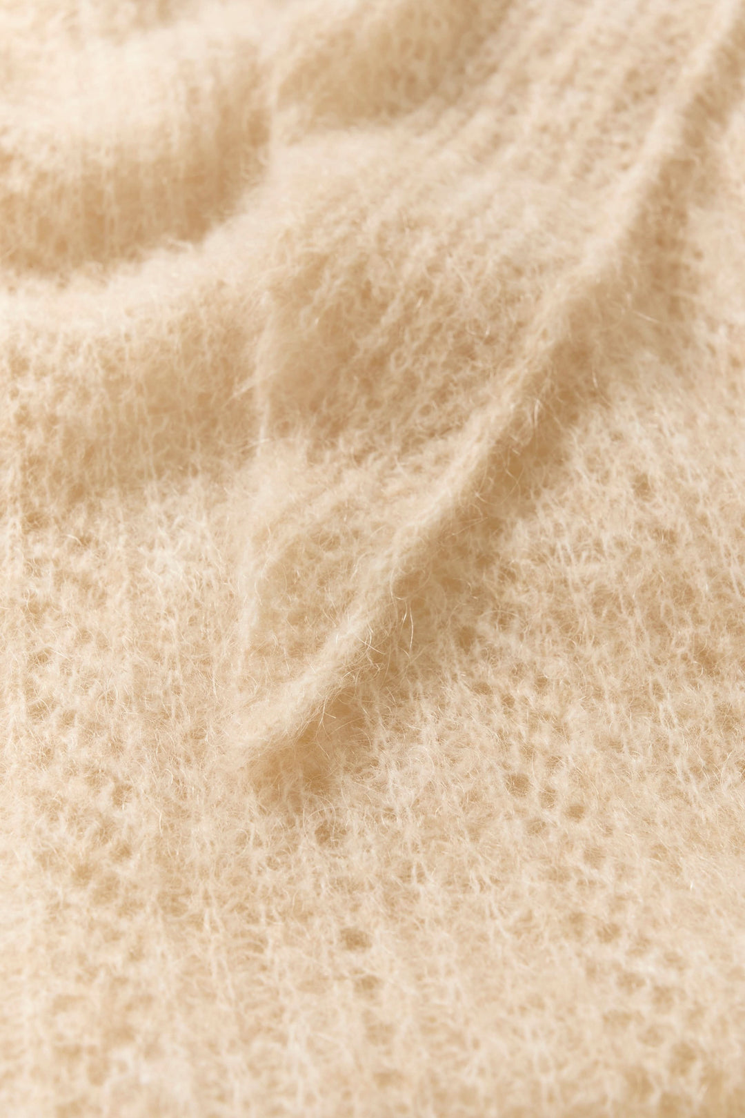 Détail du foulard Sizze en tricot léger, doux et duveteux, idéal pour un style minimaliste et moderne.