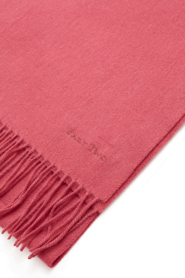 Foulard en laine Kitha de couleur rose, doux et chaud, parfait pour les tenues hivernales avec des franges élégantes.