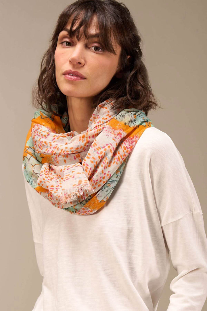 Foulard imprimé en coton bio, drapé autour du cou, ajoutant une touche sophistiquée à une tenue décontractée.