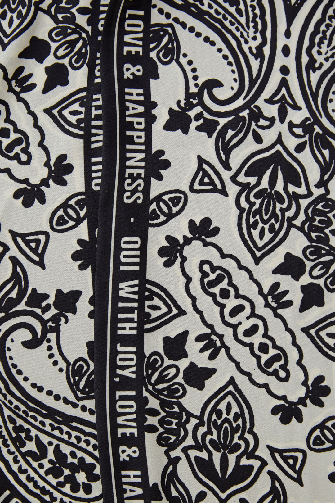 Foulard imprimé graphique avec motifs noirs et blancs, idéal pour ajouter une touche élégante et polyvalente à toutes les tenues.