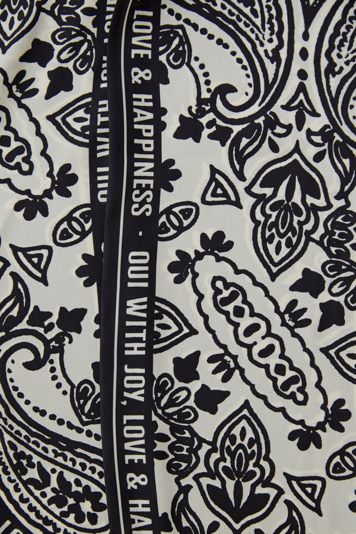 Foulard imprimé graphique avec motifs noirs et blancs, idéal pour ajouter une touche élégante et polyvalente à toutes les tenues.