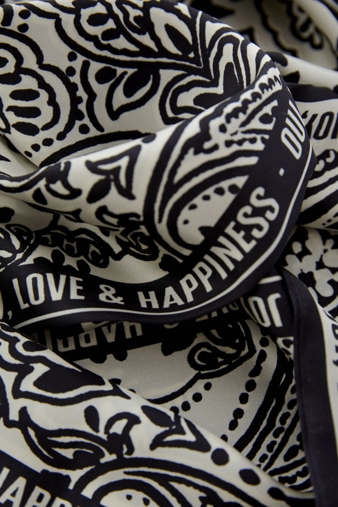 Foulard imprimé graphique avec texte "Love &amp; Happiness" sur tissu fluide en noir et blanc, ajout élégant et polyvalent aux tenues.