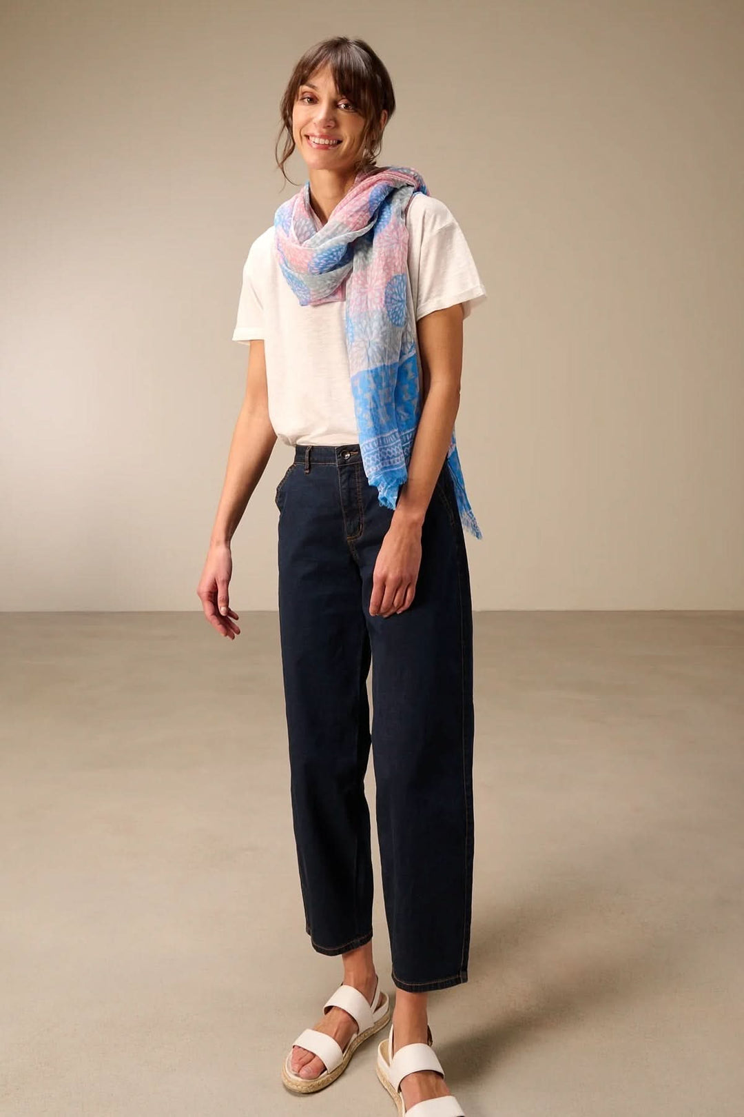 Foulard léger à imprimé porté par une femme, ajoutant une touche élégante et colorée à une tenue décontractée.