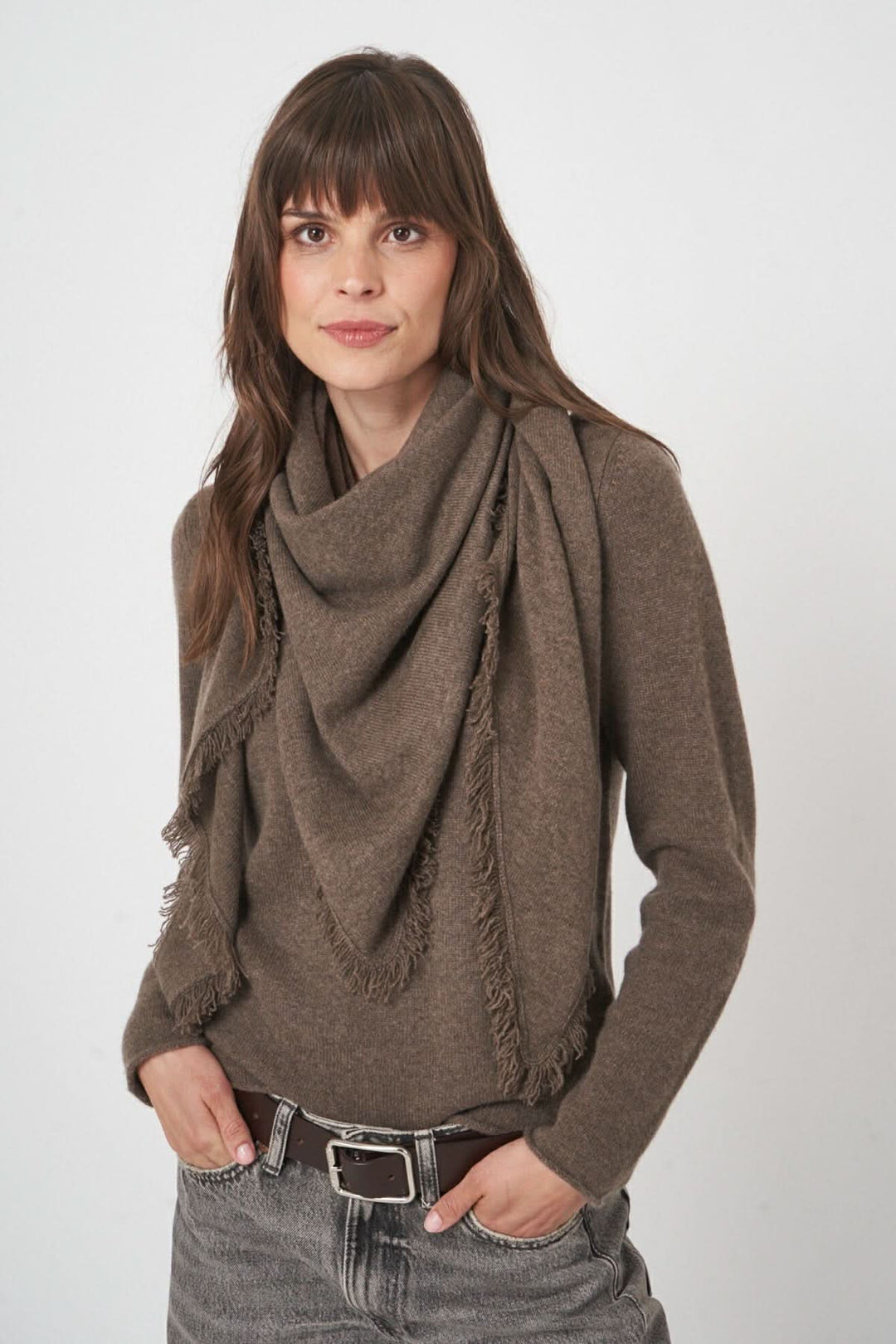 Foulard triangulaire en maille douce avec franges, porté avec un pull pour un style automnal élégant.