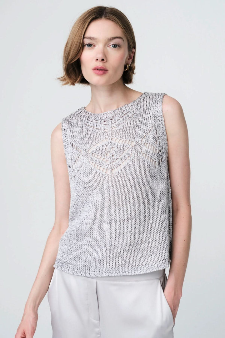 Haut sans manches en maille ajourée à motif délicat, coupe droite, porté par une femme, idéal pour un style contemporain et raffiné.