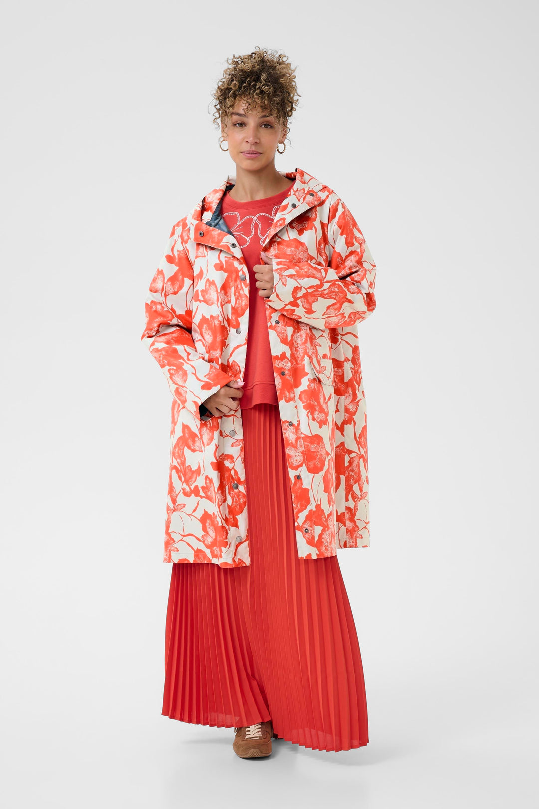 Imperméable Olif motif floral, coupe droite, longueur sous le genou, moderne et fonctionnel pour jours pluvieux, porté par un mannequin.