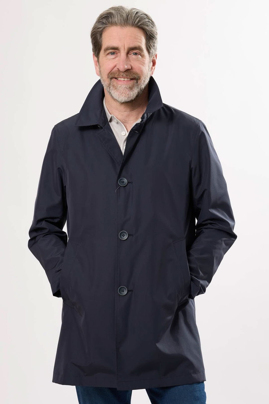 Homme portant un imperméable à col structuré, élégant et léger, parfait pour les jours de pluie.