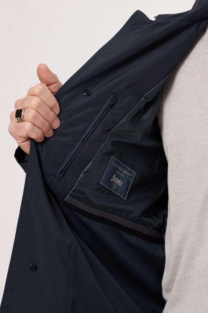 Intérieur d'un imperméable navy avec poches et étiquette de marque, offrant un style moderne et fonctionnel.