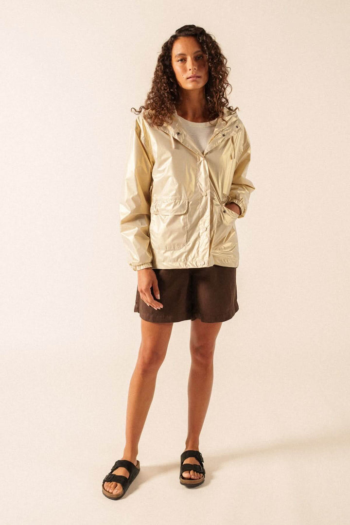 Femme portant un imperméable léger à capuche STE IRIS, coupe moderne et confortable, idéal pour mi-saison et style urbain décontracté.