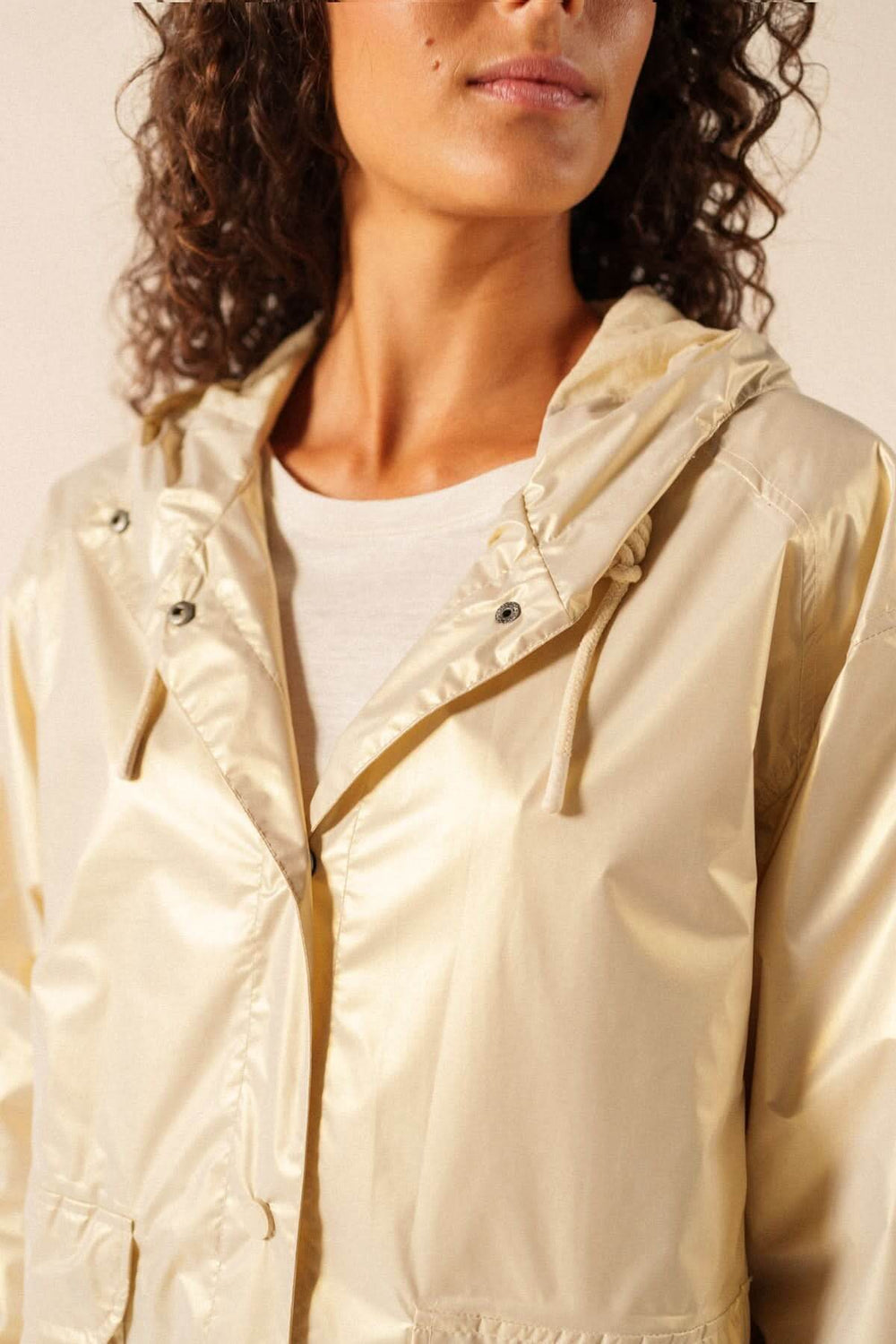 Femme portant l'Imperméable léger à capuche STE IRIS, style moderne et matière déperlante, idéale pour la mi-saison.