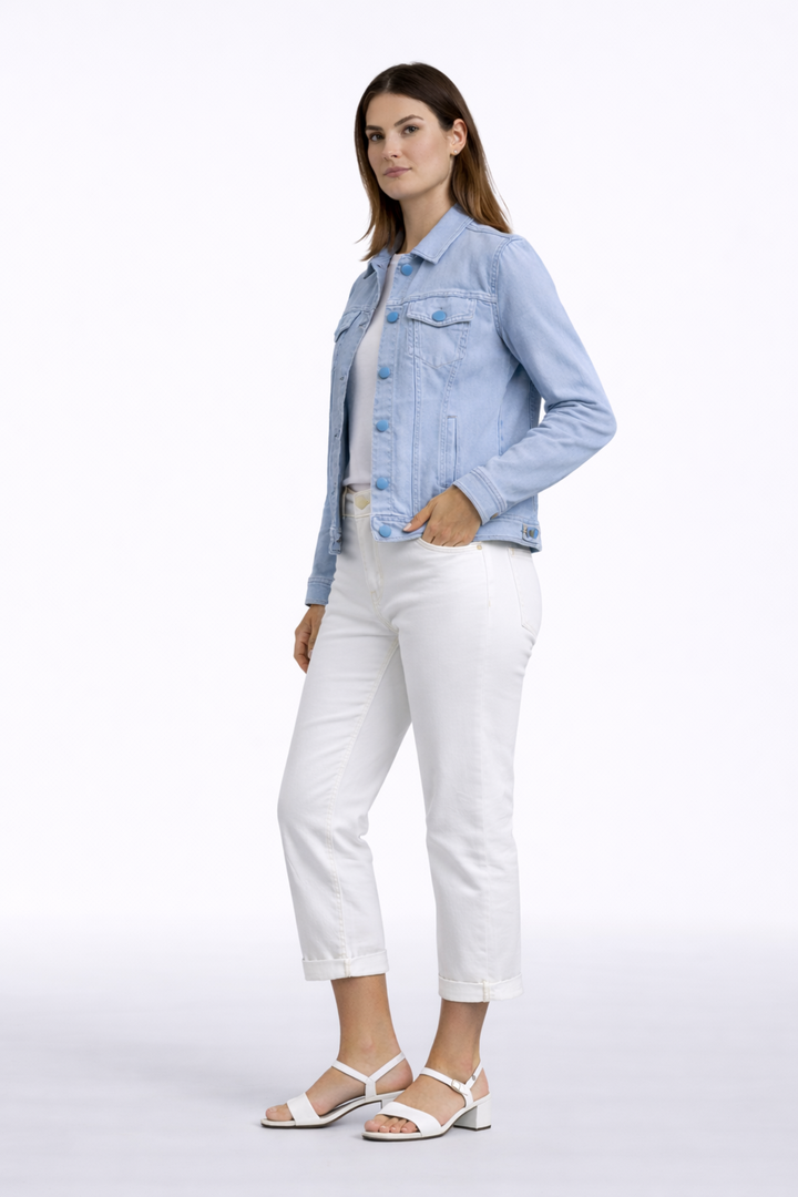 Femme portant une Jacket de style denim avec un col structuré et poches à rabat, sur une tenue décontractée en blanc.