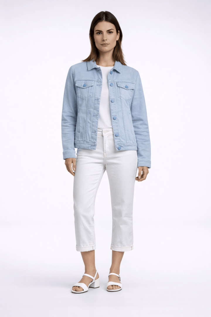 Jacket de style denim bleu clair avec poches à rabat et fermeture boutonnée, portée par une femme, coupée dans une silhouette épurée.