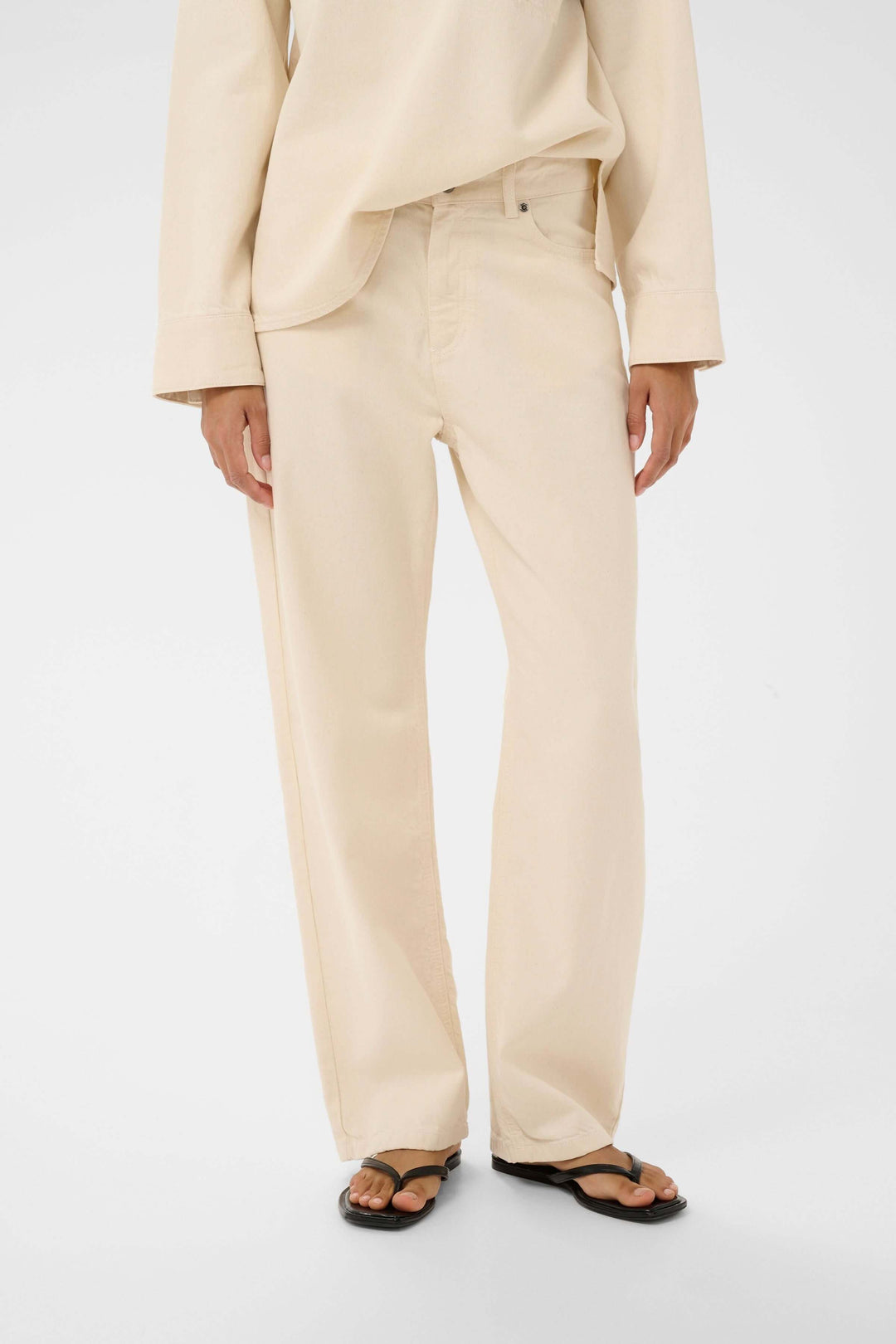 Jean Dilys droit classique beige avec coupe droite et taille avec passants, porté par une personne.