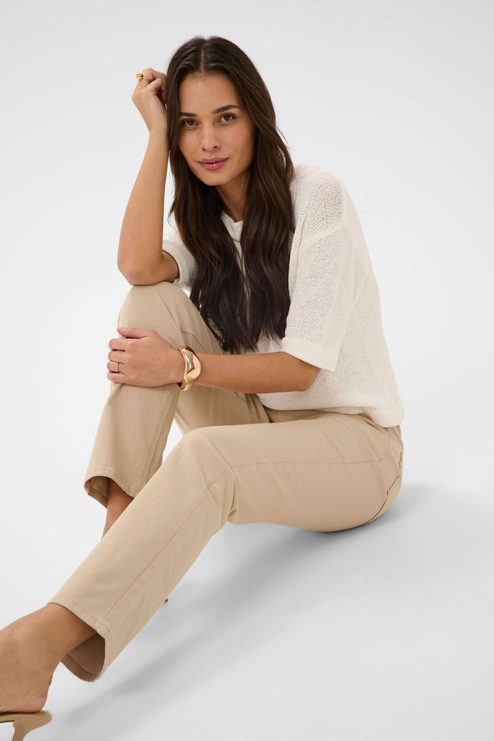 Femme portant un Jean Harriet coupe droite ajustée beige, silhouette épurée et confortable, tenue quotidienne élégante et polyvalente.