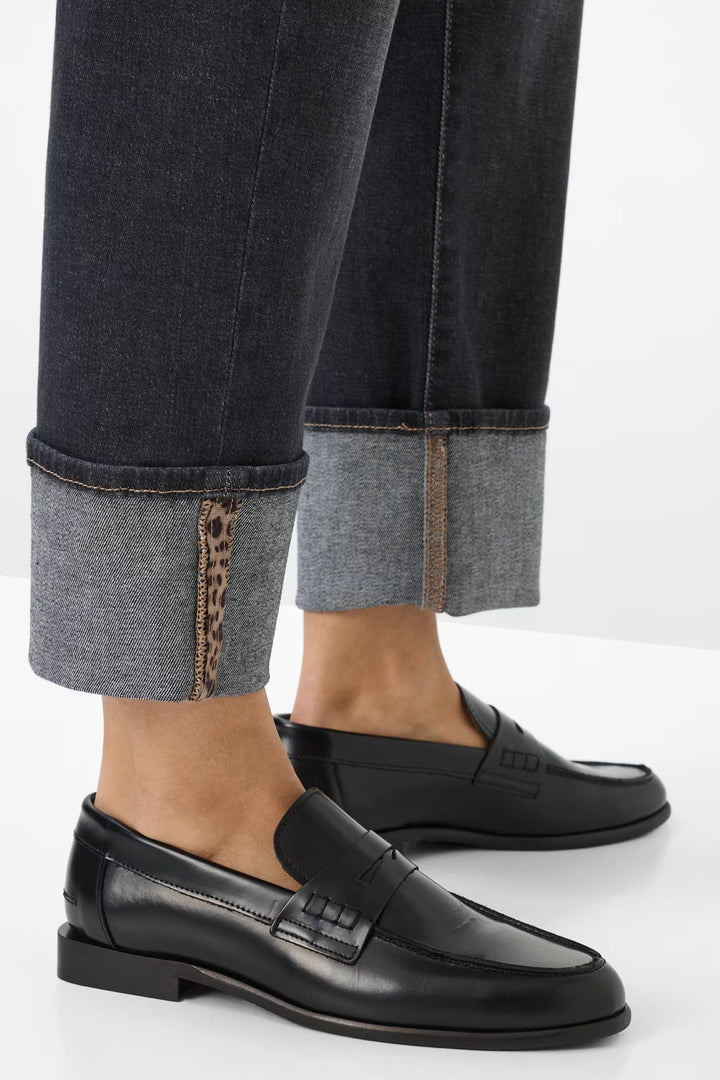 Jean avec revers contrastés et chaussures noires élégantes, mettant en avant un look moderne et stylé.