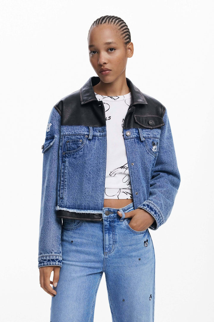 Jean Mickey à broderies Mickey Mouse, coupe large, denim bleu avec veste en cuir et t-shirt graphique, look urbain décontracté.