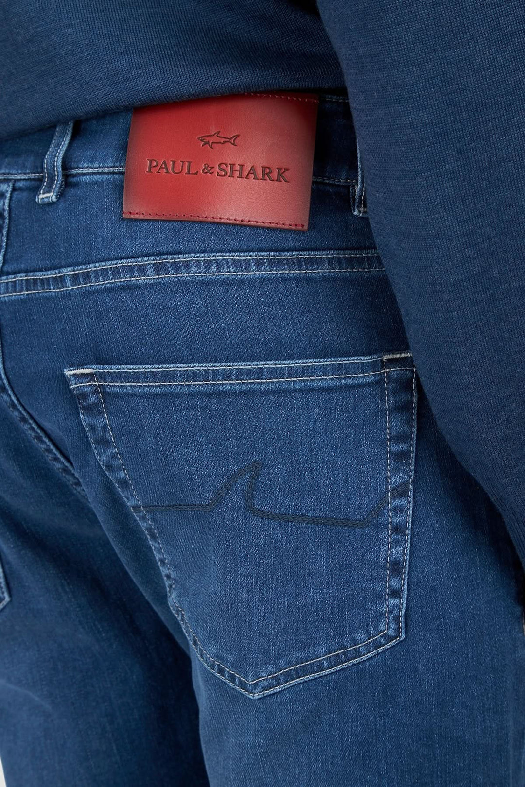 Gros plan arrière du Jean Red Rivet coupe régulière avec une étiquette en cuir rouge sur la poche.