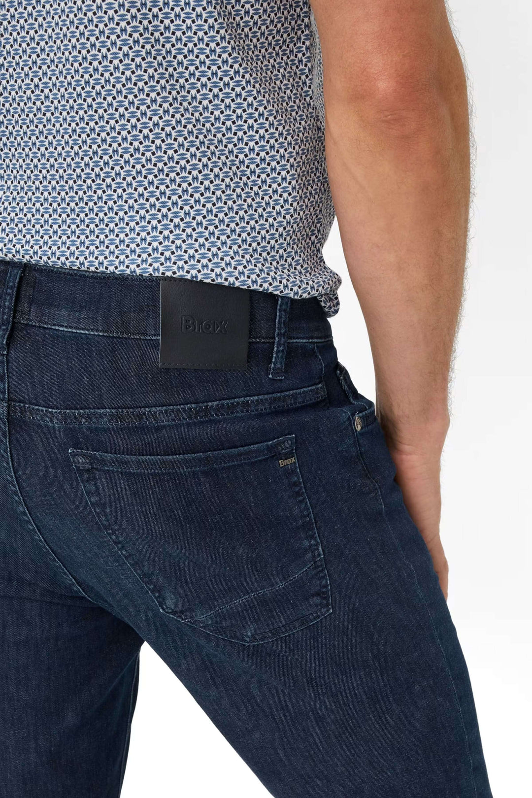 Jean cinq poches en denim bleu, coupe moderne, montre le dos avec détail de la ceinture, style chic et décontracté.