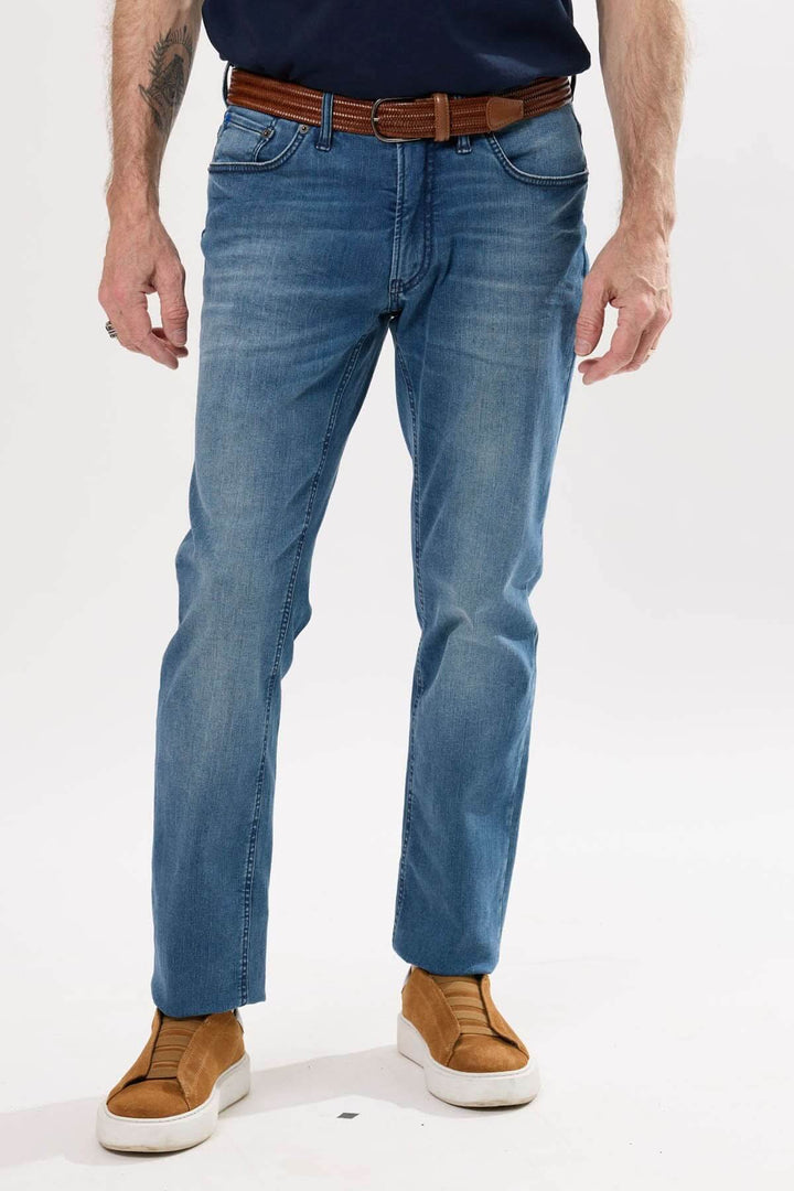 Jean coupe droite en denim légèrement extensible avec effet usé, porté avec un t-shirt et une ceinture en cuir.