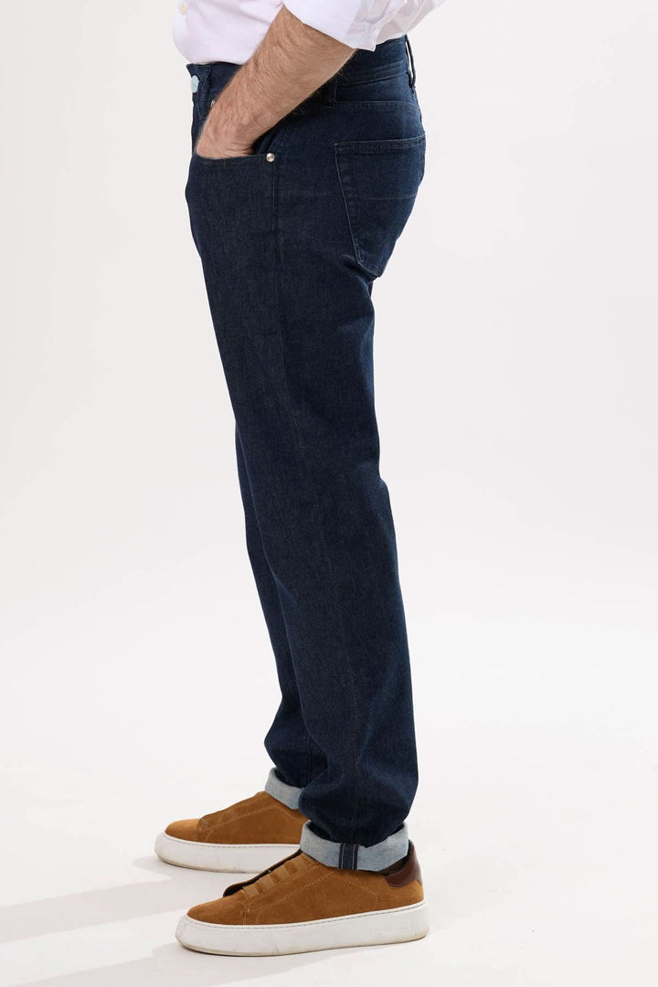 Jean coupe droite en denim brut, confortable avec five poches, porté avec des chaussures décontractées.