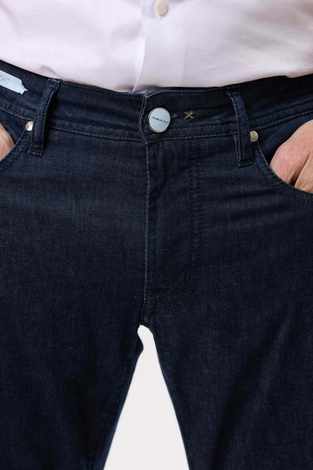 Jean coupe droite en denim brut, taille ajustée, avec cinq poches et bouton en métal.