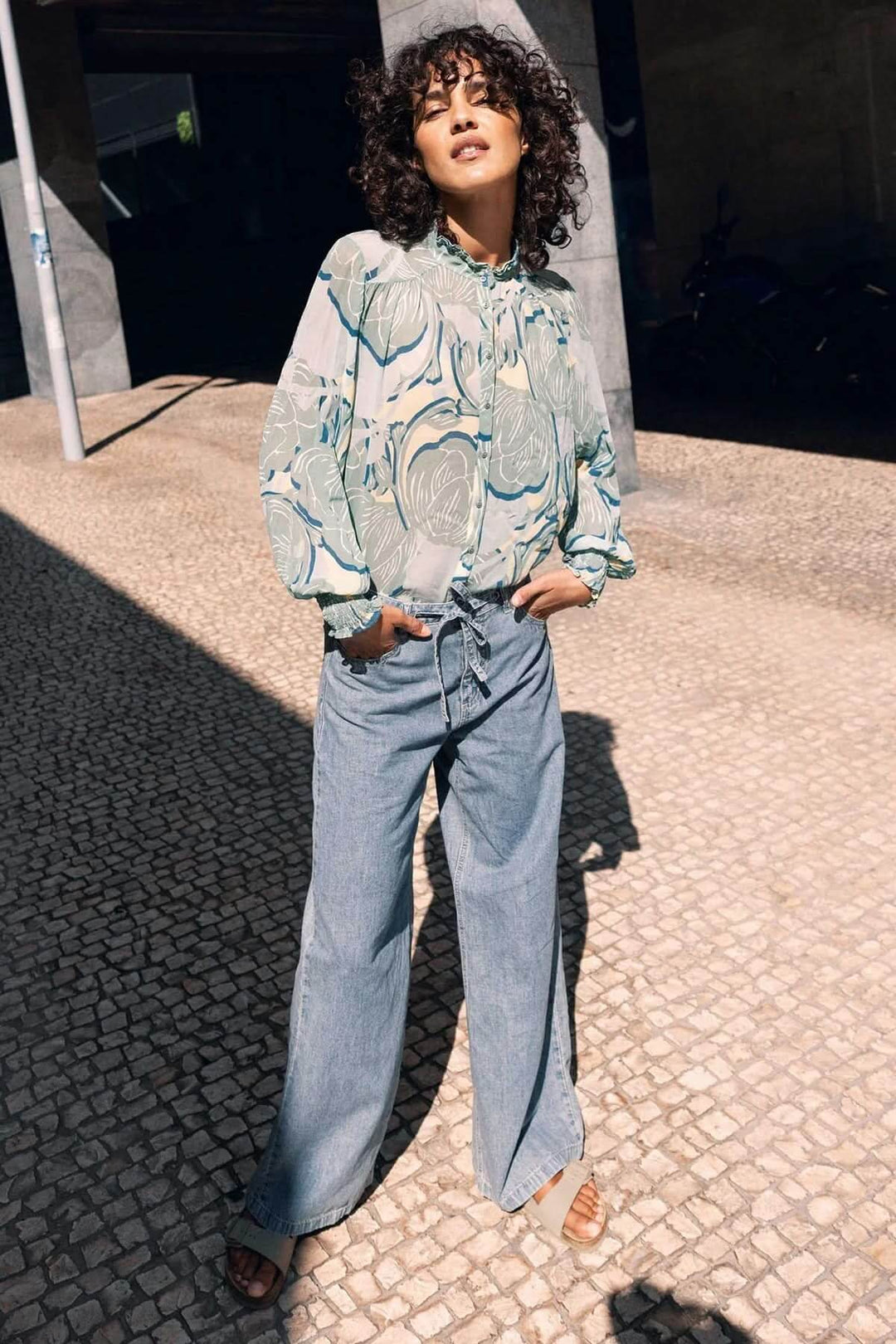 Jean à jambe large avec ceinture à nouer pour une silhouette moderne et décontractée, en denim souple et ample. Description en français.
