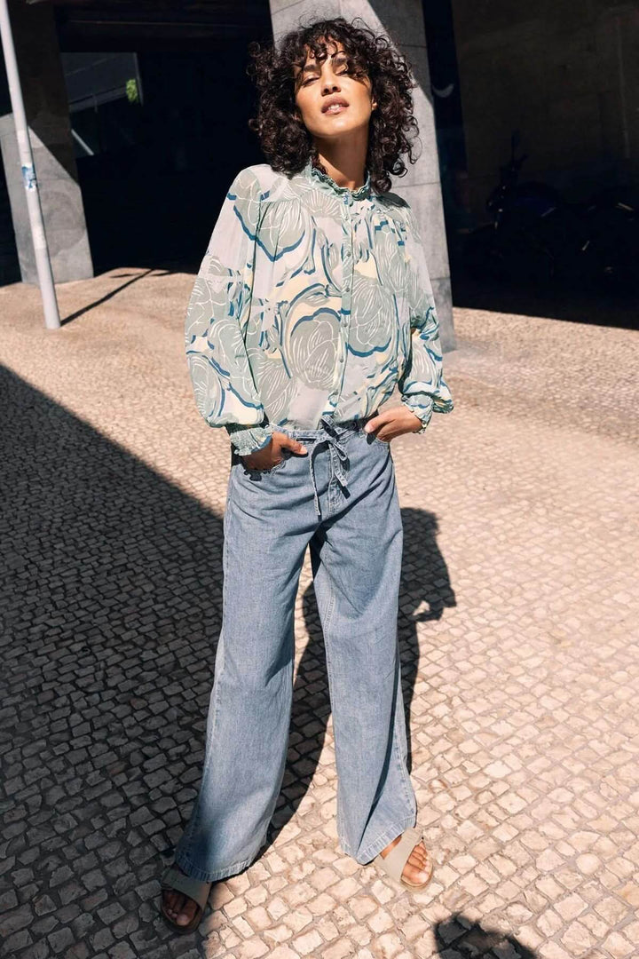 Jean à jambe large avec ceinture à nouer pour une silhouette moderne et décontractée, en denim souple et ample. Description en français.