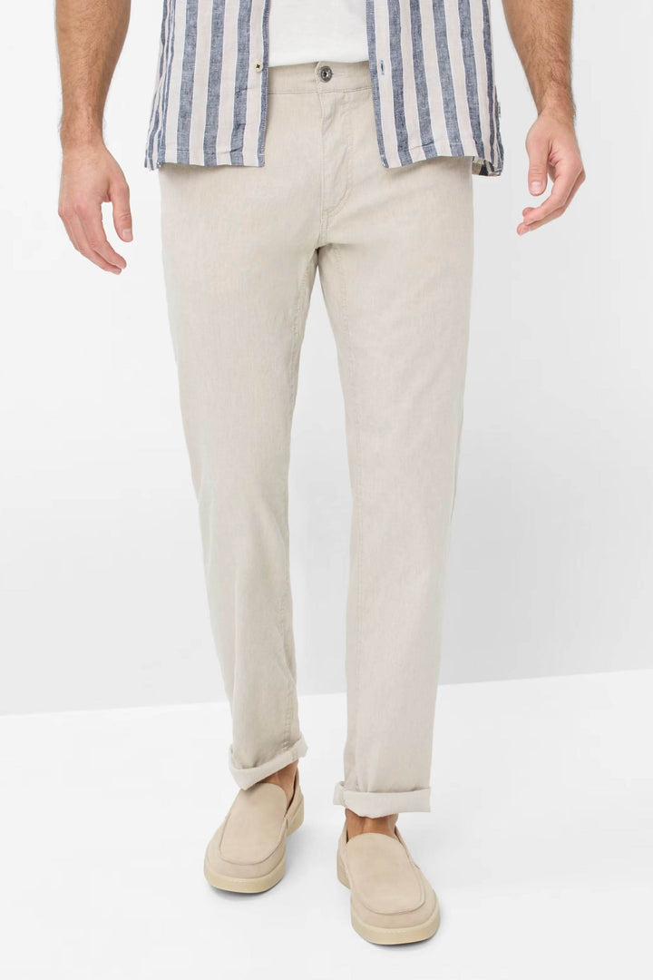 Jean coupe décontractée en lin léger, porté avec une chemise rayée, parfait pour un style estival.