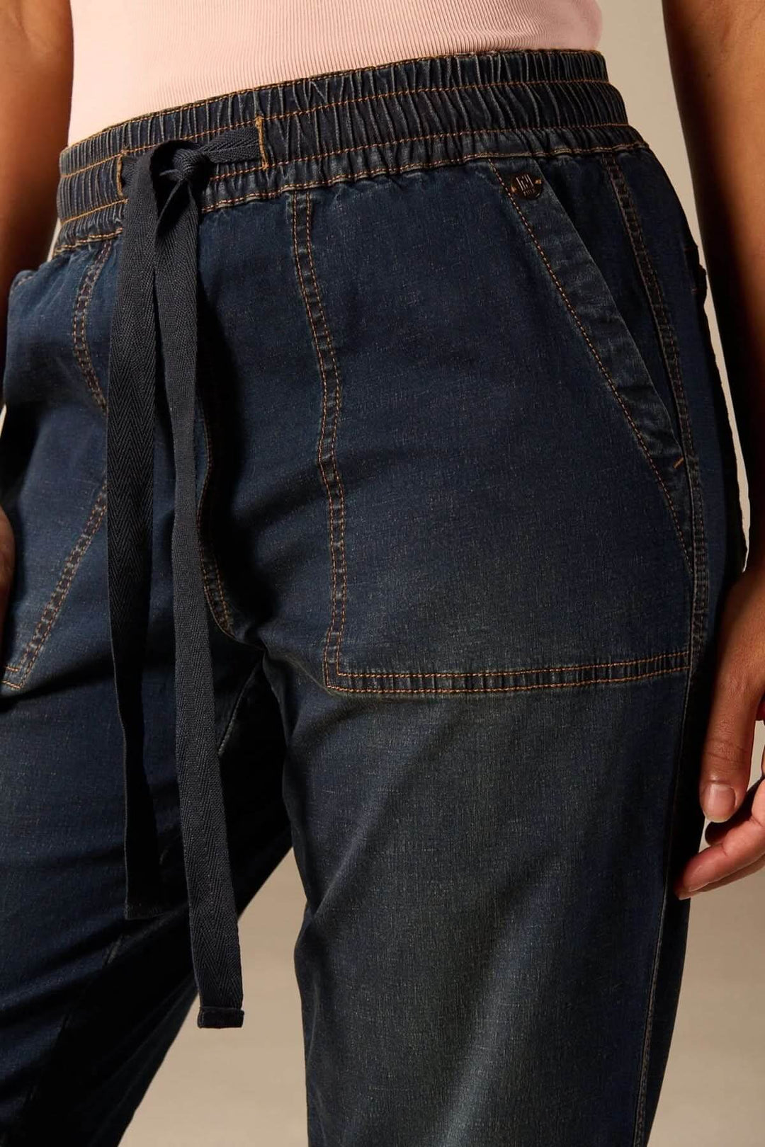 Gros plan sur le Jeanjogging à taille élastique avec cordon ajustable, coupe fuselée moderne pour un look décontracté et confortable.