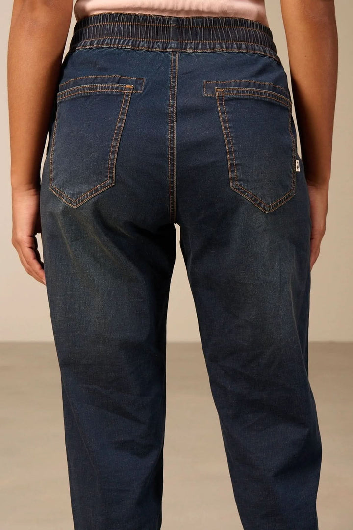 Jeanjogging à taille élastique en denim confortable et fuselé, vue de dos, avec poches arrières et cordon ajustable.