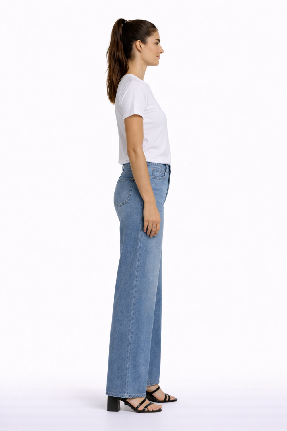 Femme portant des jeans à coupe droite légèrement ajustée en denim extensible, taille mi-haute, avec un t-shirt blanc pour un look moderne.