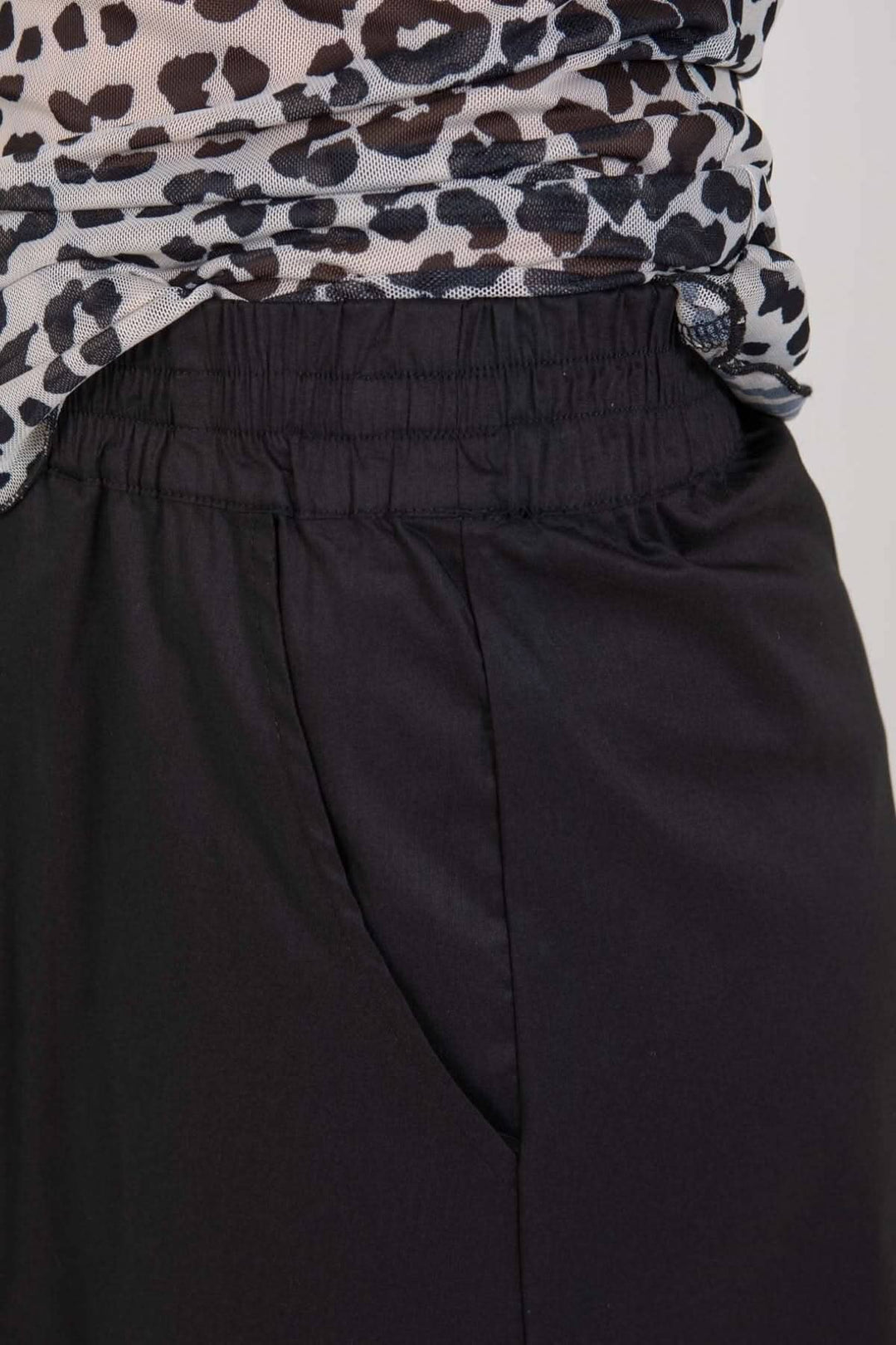 Zoom sur la taille élastiquée et les poches de la jupe courte noire.