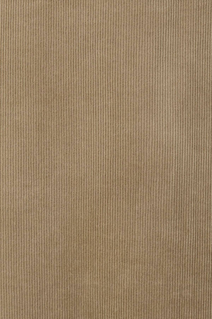 Tissu en velours côtelé souple de couleur beige, texture douce et côtelée, idéal pour des vêtements élégants.
