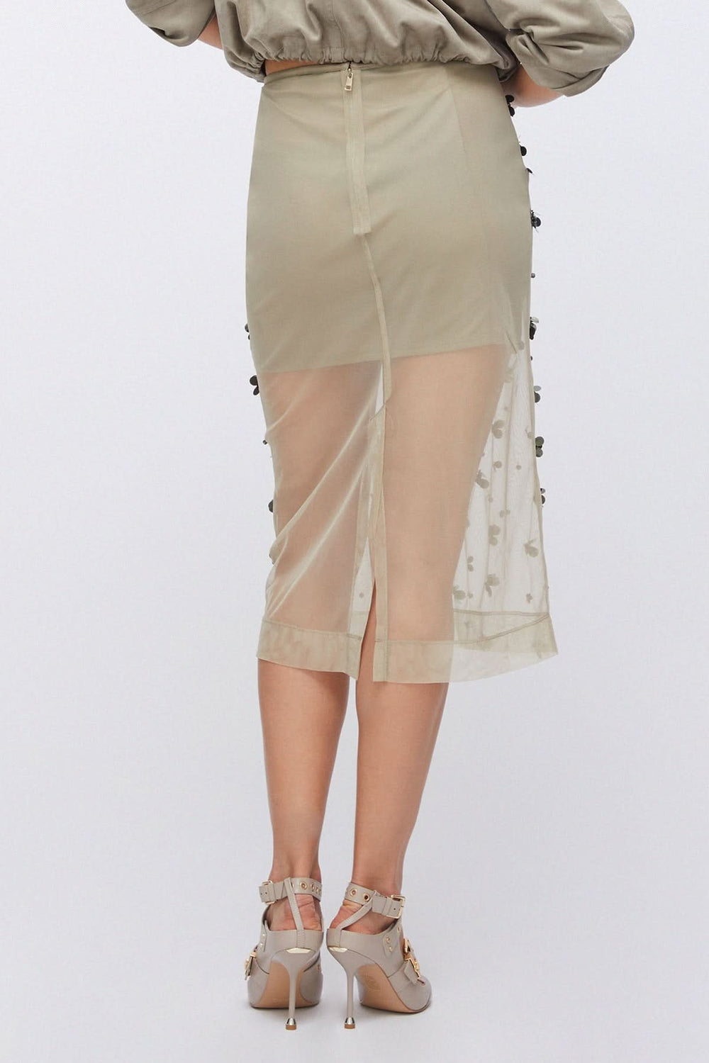 Vue arrière d'une jupe en maille transparente ornée, avec détails appliqués et effet texturé, style moderne et raffiné.