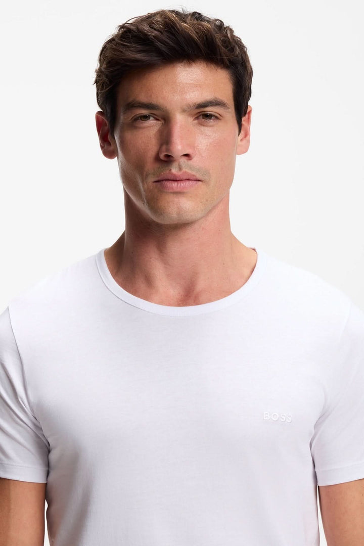 Homme portant un t-shirt blanc du lot de trois t-shirts en coton à logo brodé, encolure ronde et design épuré.