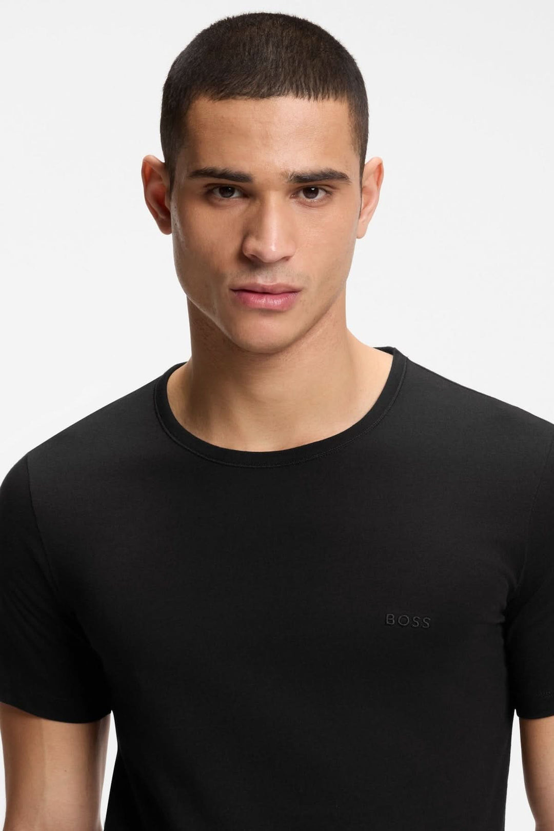 Homme portant un t-shirt noir du lot de trois t-shirts en coton à logo brodé, mettant en valeur le design épuré et le logo discret.