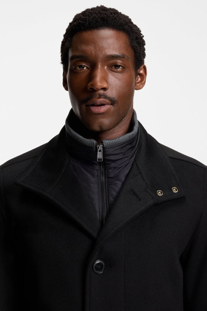 Homme portant un manteau en laine et cachemire Coxtan par BOSS, coupe décontractée, sur fond blanc. Mode élégante et sophistiquée.