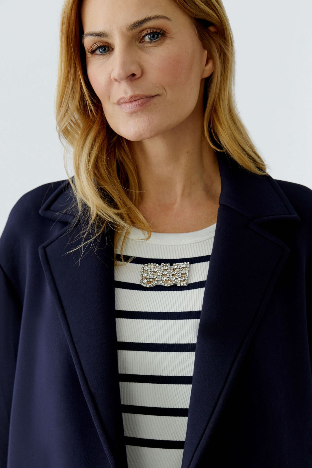 Femme portant un manteau long à coupe droite avec un design épuré et col tailleur.