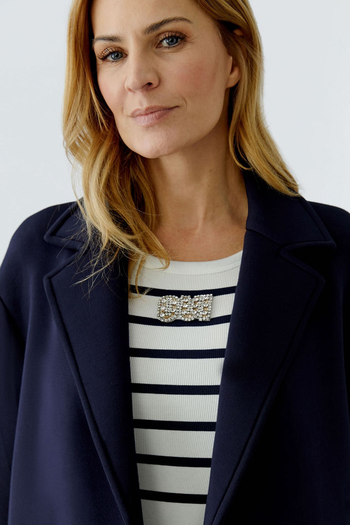 Femme portant un manteau long à coupe droite avec un design épuré et col tailleur.