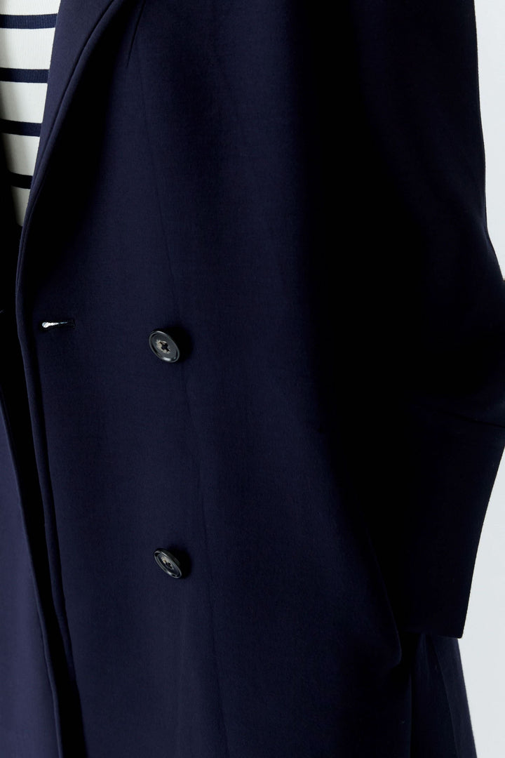 Manteau long à coupe droite avec col tailleur classique et fermeture boutonnée, élégant et polyvalent.