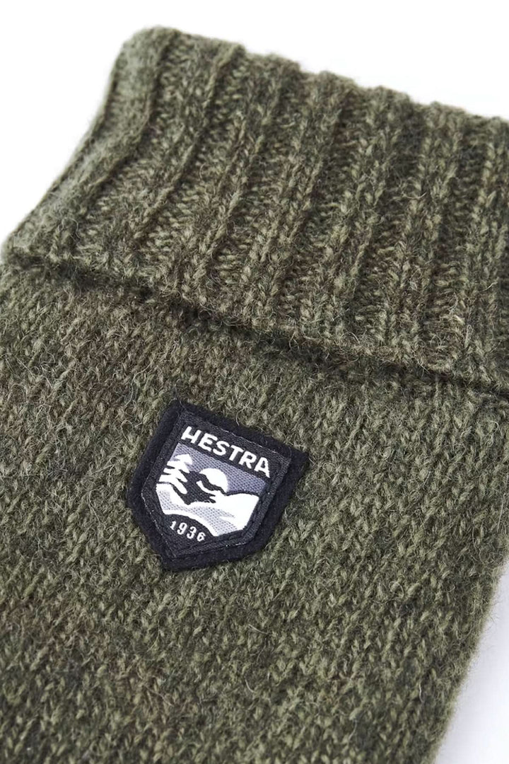 Mitaine en laine basique de couleur verte avec logo Hestra sur le revers côtelé.