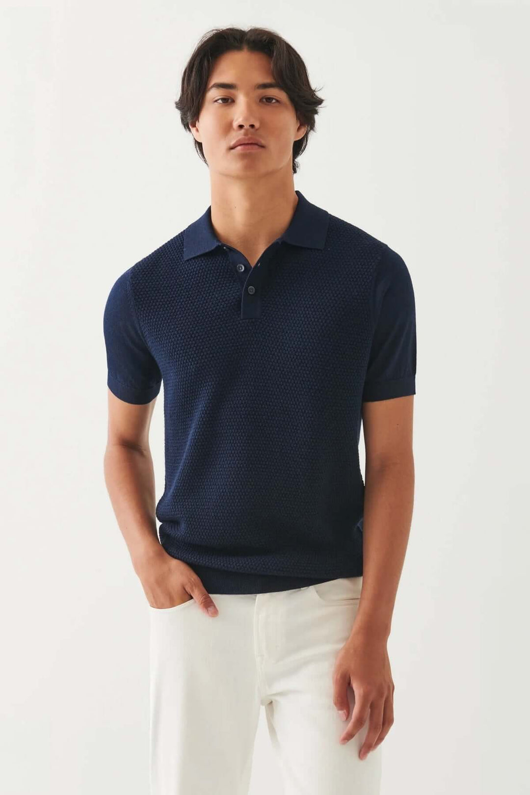 Homme portant un chandail polo bleu marine, élégant et décontracté, style moderne avec récemment ajustement.