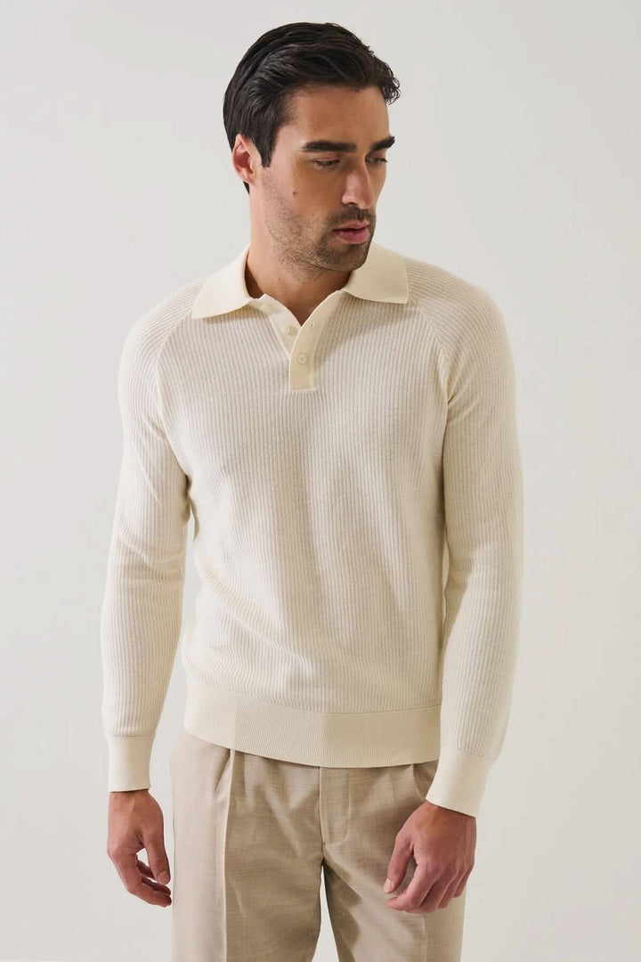 Homme portant un POLO EN MAILLE CÔTELÉE beige avec manches raglan pour une allure moderne et un confort optimal.